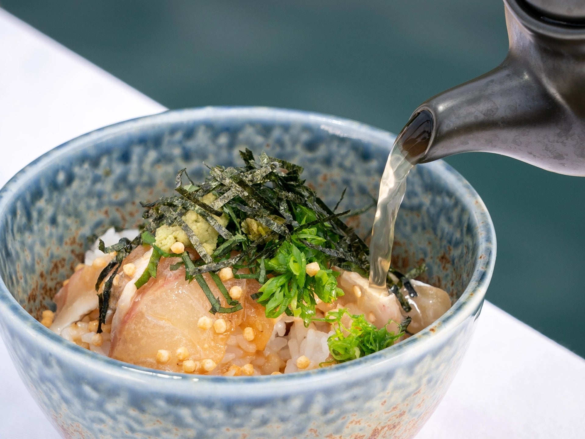 丼に急須で出汁を注ぐ様子